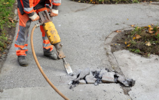 Asphalt demolishing, worker and jackhammer