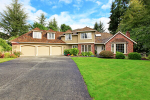 Luxury house exterior with brick trim and an asphalt driveway