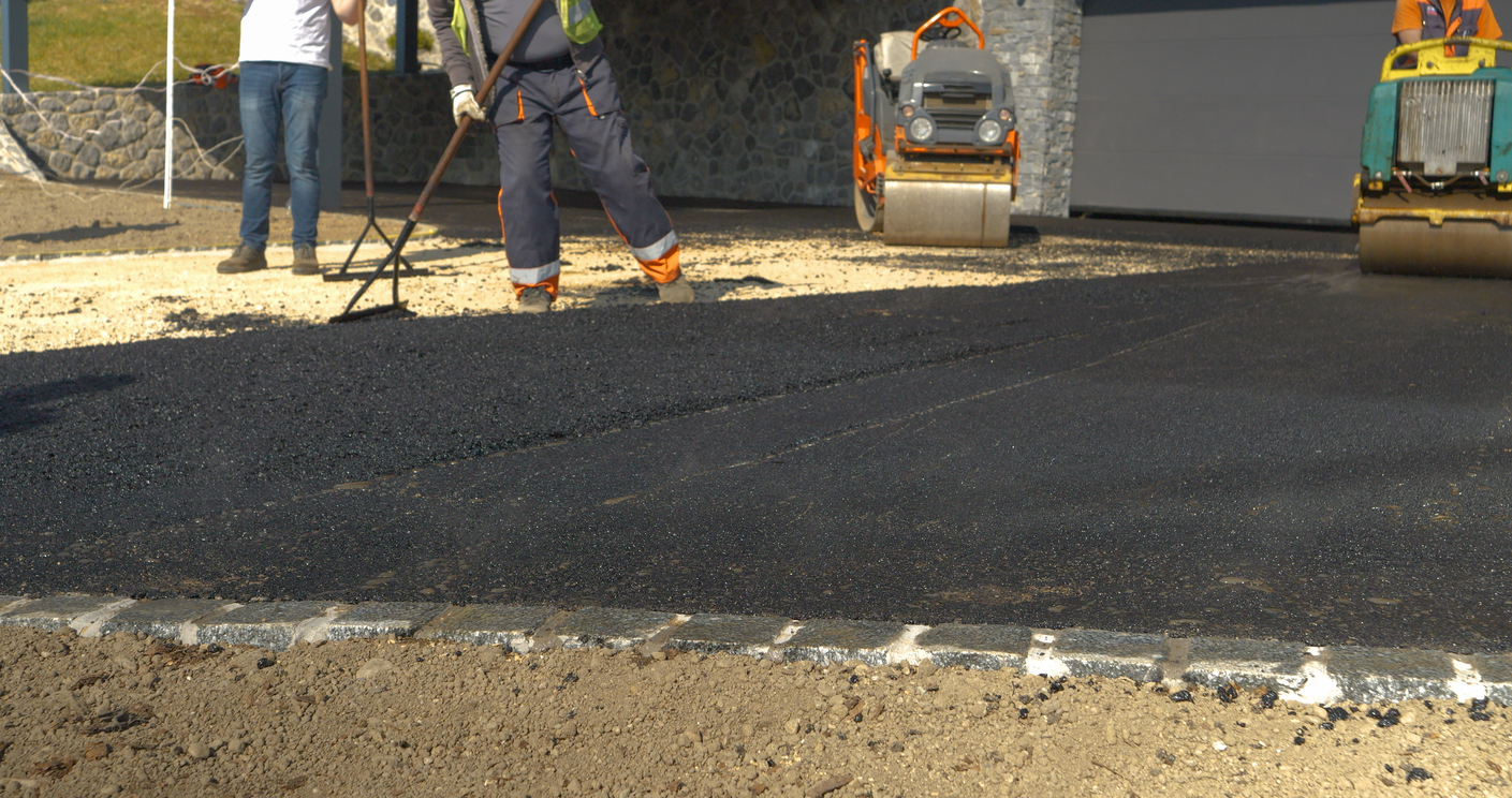 Partially asphalted and levelled fresh asphalt surface on the driveway