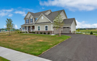 Asphalt driveway leading to three car garage