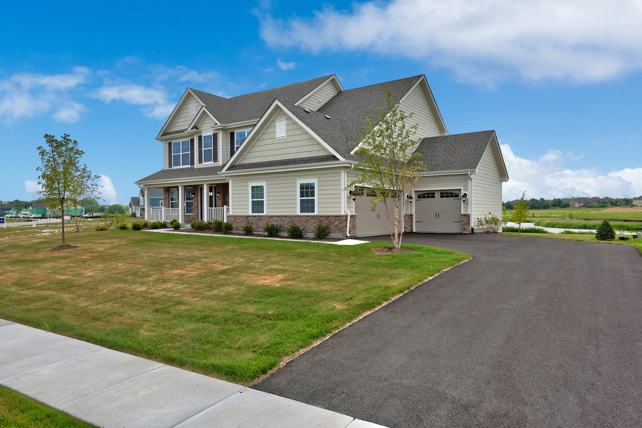 Asphalt driveway leading to three car garage