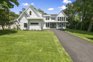 Long asphalt driveway leading to front door and side-entry garage