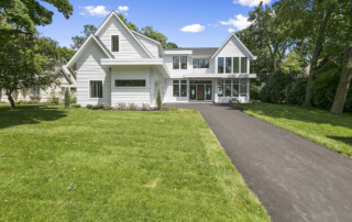 Long asphalt driveway leading to front door and side-entry garage